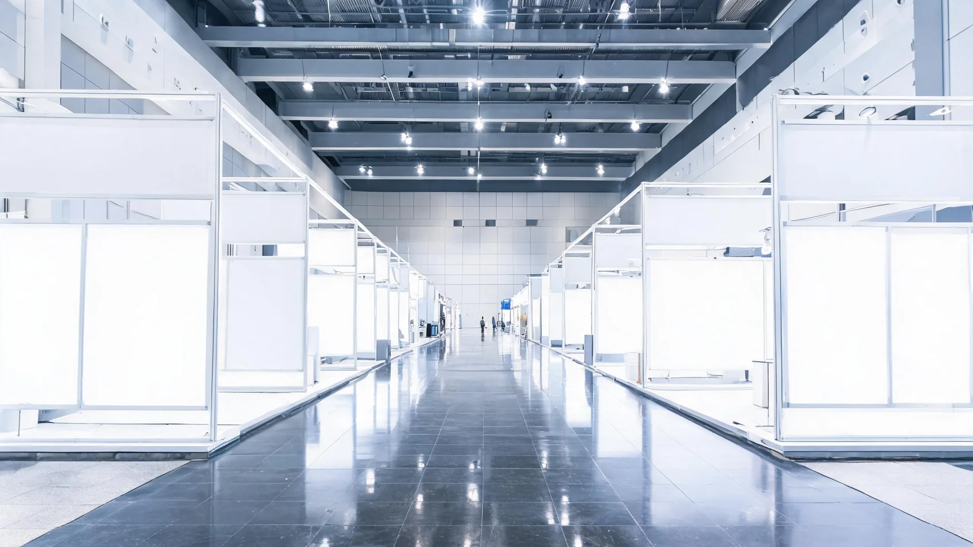 An exhibition hall with blank white booth panels before opening.